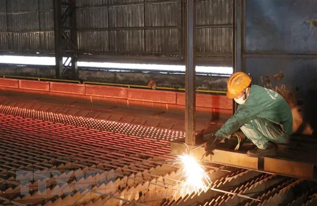 Công nhân Nhà máy cán thép Thái Trung - CTCP Gang thép Thái Nguyên lấy mẫu thép thành phẩm sau khi cán. Ảnh: Hoàng Nguyên/TTXVN